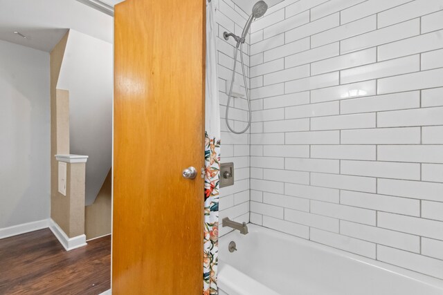 bathroom with wood-type flooring and shower / tub combo