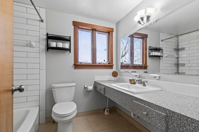 full bathroom featuring tile patterned flooring, tiled shower / bath, sink, and toilet