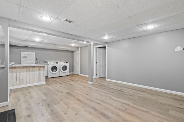 laundry room with washer and dryer and light wood-type flooring