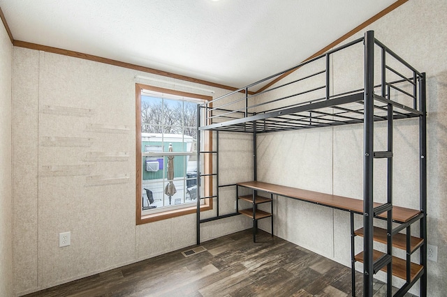 bedroom with ornamental molding and dark wood-type flooring