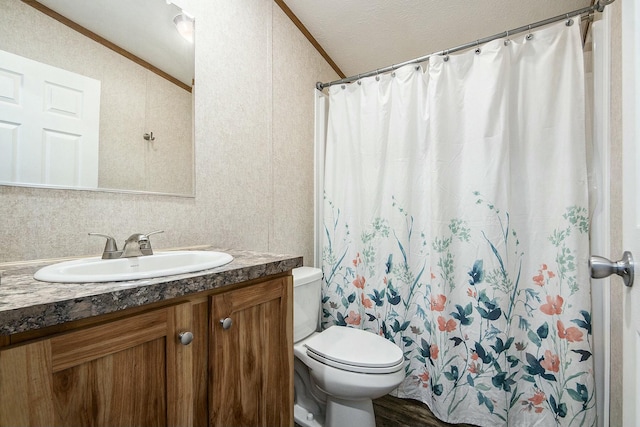 bathroom featuring vanity, crown molding, vaulted ceiling, and toilet