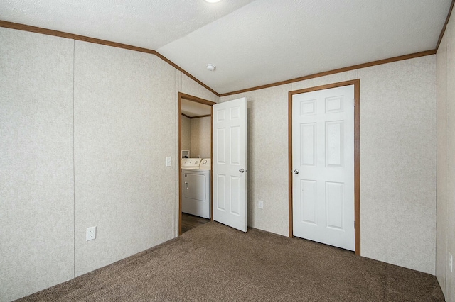 unfurnished bedroom with lofted ceiling, dark colored carpet, crown molding, separate washer and dryer, and a textured ceiling