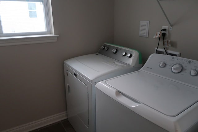 laundry area featuring washing machine and clothes dryer and dark tile patterned flooring