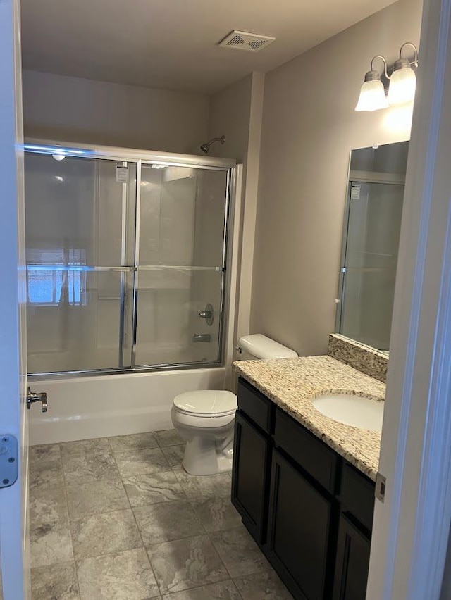 full bathroom featuring vanity, toilet, and combined bath / shower with glass door