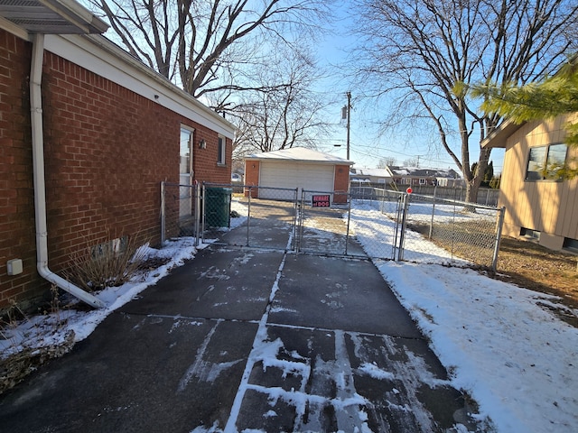 view of snow covered exterior featuring an outbuilding and a garage