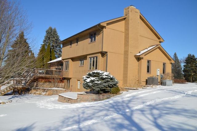 view of snowy exterior featuring central air condition unit