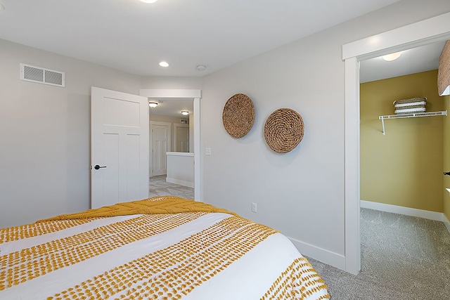 carpeted bedroom with a spacious closet and a closet