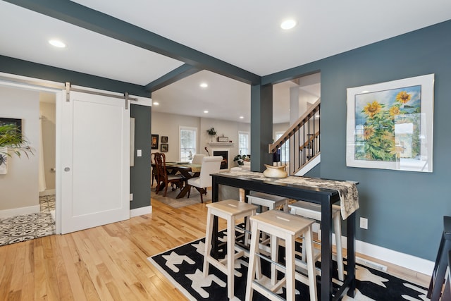 dining space featuring a barn door and light hardwood / wood-style floors