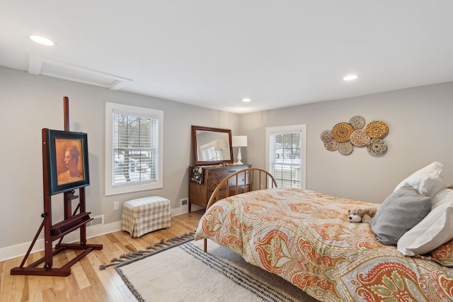 bedroom with multiple windows and light hardwood / wood-style floors