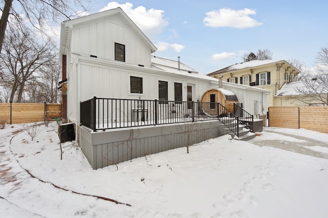 snow covered back of property featuring cooling unit