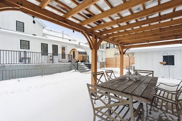 snow covered patio featuring a pergola