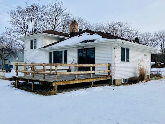 snow covered house featuring a deck