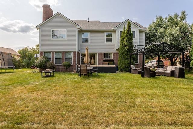 rear view of house featuring a yard, a gazebo, and an outdoor living space with a fire pit