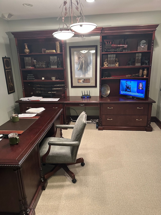 carpeted office space with built in desk