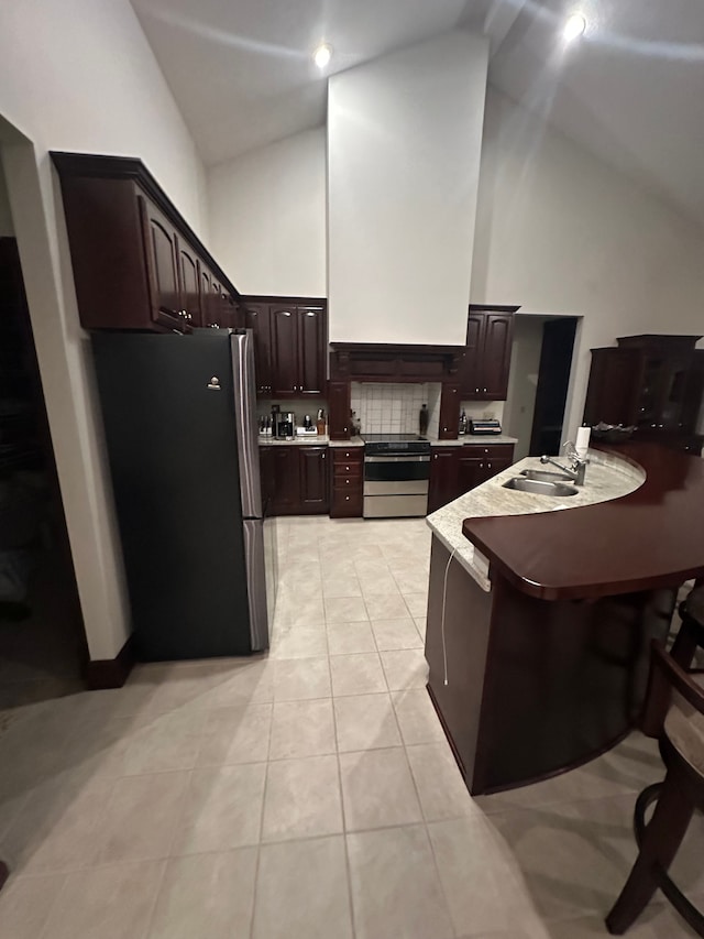 kitchen with high vaulted ceiling, sink, decorative backsplash, stainless steel appliances, and dark brown cabinets