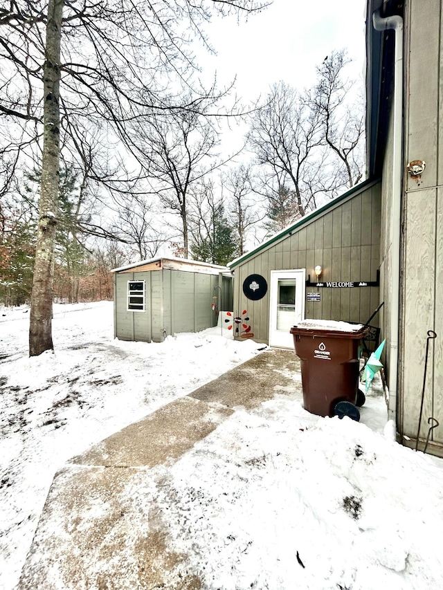 yard layered in snow with an outdoor structure