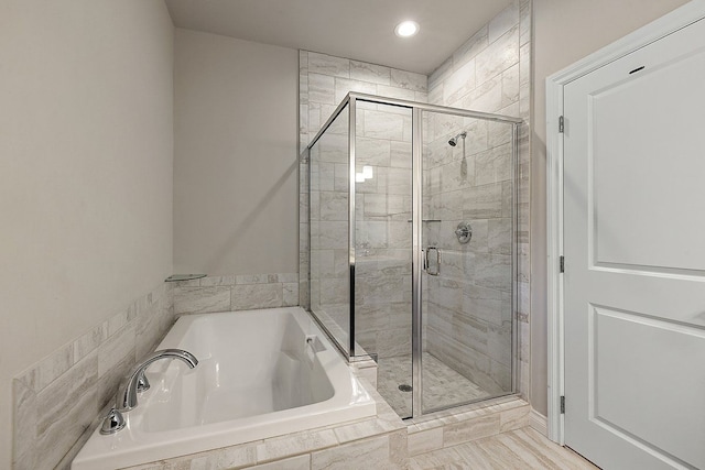 bathroom featuring shower with separate bathtub