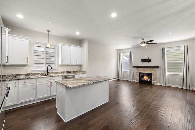 kitchen featuring pendant lighting, a kitchen island, and white cabinets