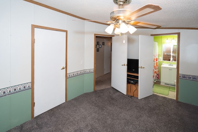 carpeted spare room featuring sink, crown molding, a textured ceiling, and ceiling fan