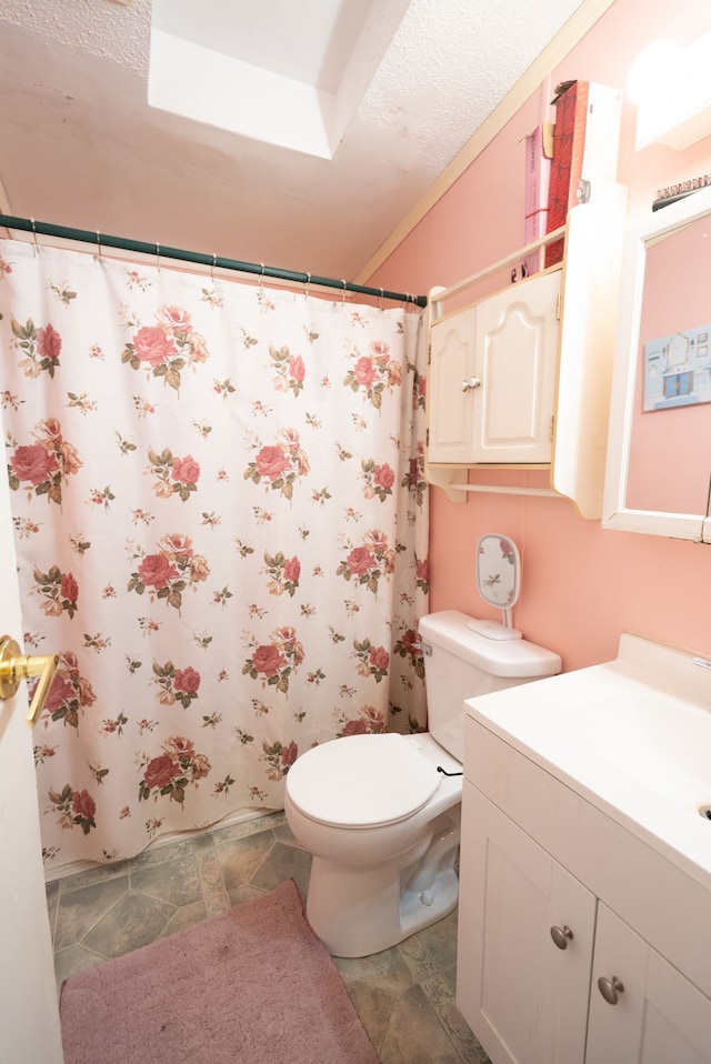 bathroom featuring a shower with curtain, vanity, toilet, and a textured ceiling