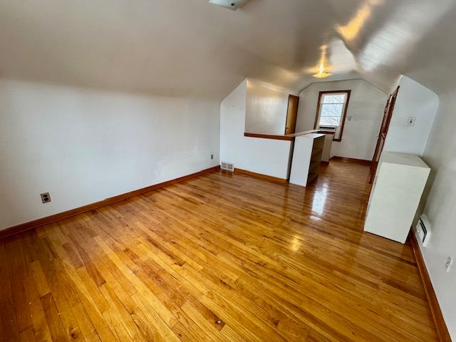 bonus room featuring lofted ceiling and hardwood / wood-style floors