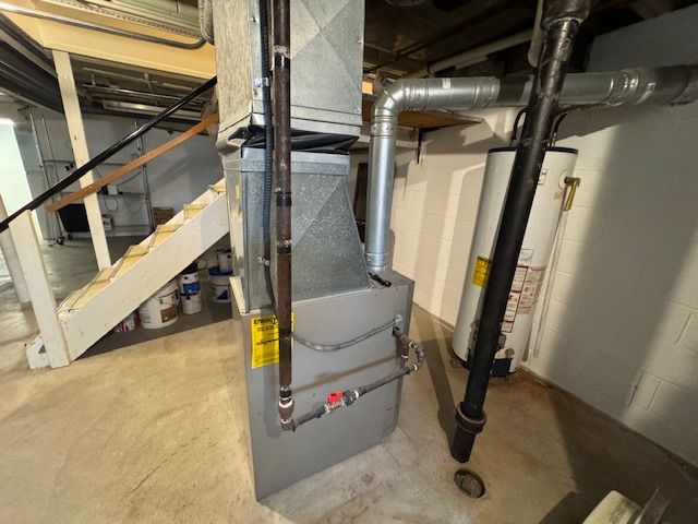 utility room featuring heating unit and water heater