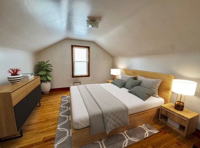 bedroom featuring wood-type flooring and vaulted ceiling