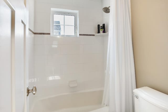 bathroom with toilet and shower / bath combo with shower curtain