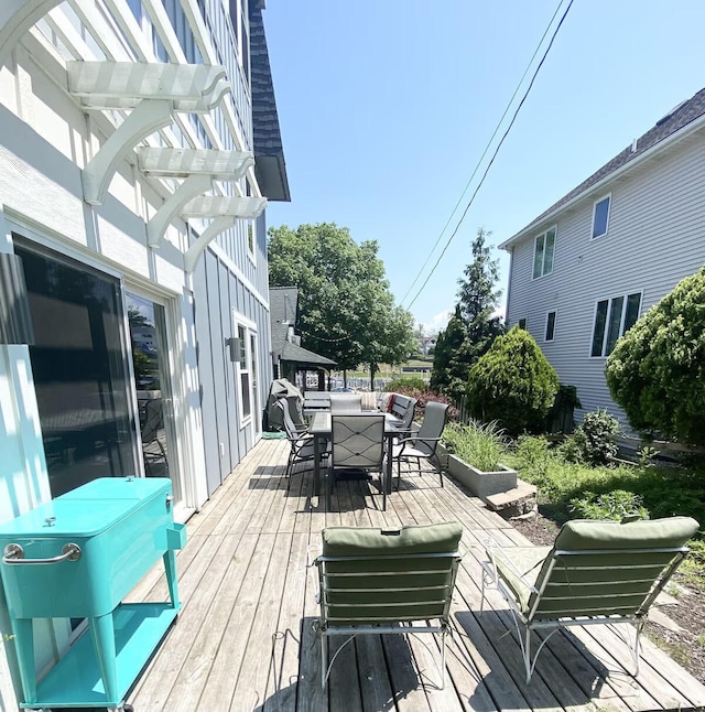 wooden deck with area for grilling and a pergola