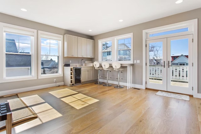 kitchen with french doors, sink, wine cooler, and light hardwood / wood-style flooring