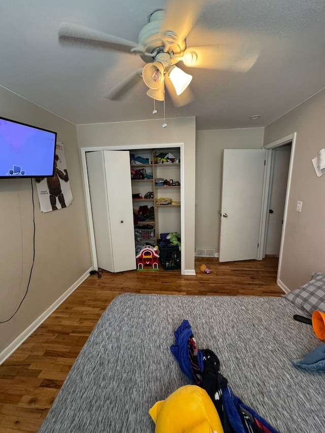 bedroom featuring wood-type flooring, ceiling fan, and a closet