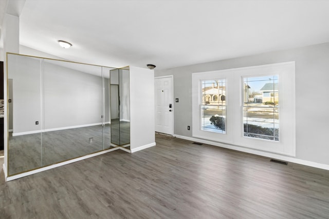 unfurnished bedroom featuring vaulted ceiling and dark wood-type flooring