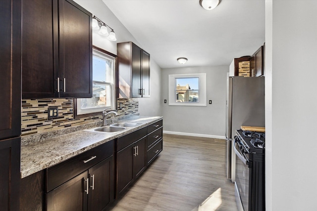 kitchen featuring tasteful backsplash, gas stove, plenty of natural light, and sink