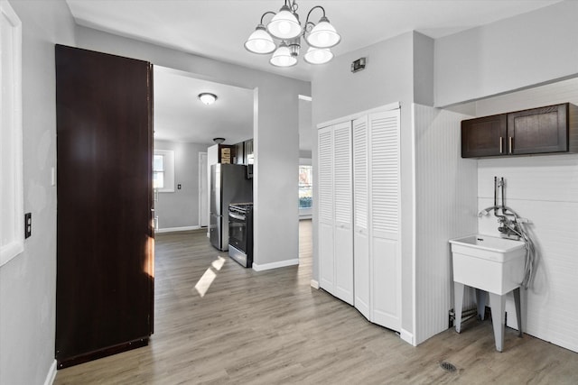 hall featuring plenty of natural light, light hardwood / wood-style floors, and a notable chandelier