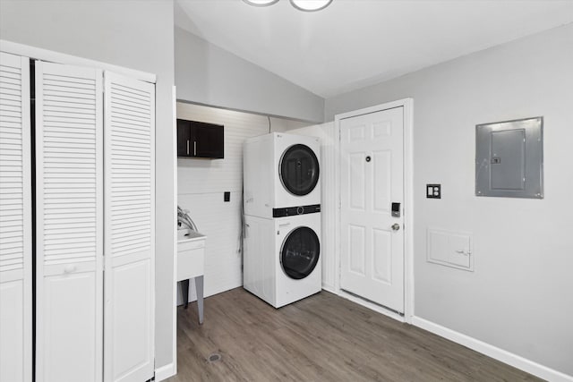 washroom featuring cabinets, stacked washer / dryer, electric panel, and wood-type flooring