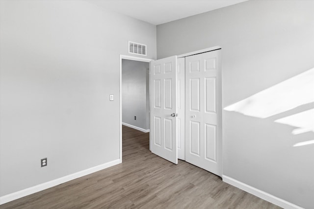 unfurnished bedroom with hardwood / wood-style flooring and a closet