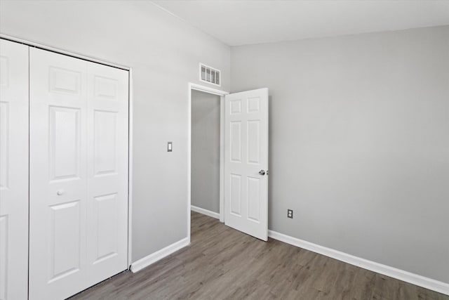 unfurnished bedroom featuring hardwood / wood-style floors and a closet