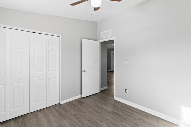 unfurnished bedroom featuring ceiling fan, dark hardwood / wood-style flooring, and a closet