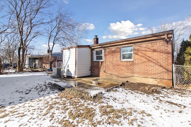 snow covered property featuring central air condition unit