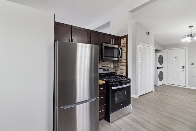 kitchen with stacked washing maching and dryer, an inviting chandelier, backsplash, appliances with stainless steel finishes, and dark brown cabinets