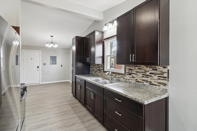 kitchen featuring pendant lighting, refrigerator, tasteful backsplash, vaulted ceiling with beams, and sink