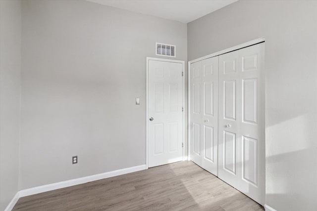 unfurnished bedroom featuring a closet and light wood-type flooring