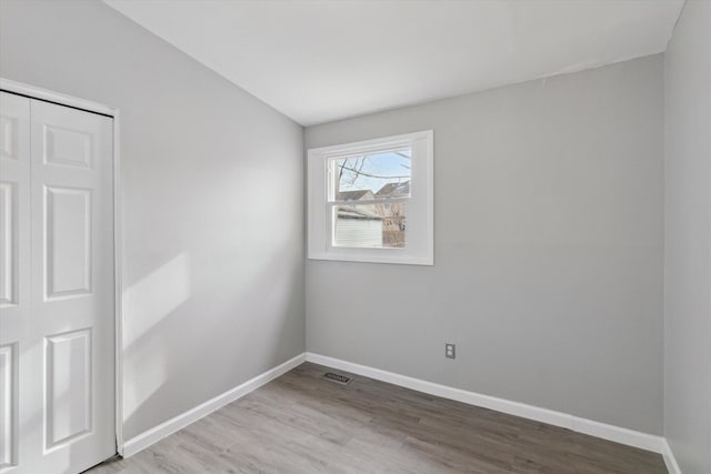 unfurnished room with hardwood / wood-style flooring