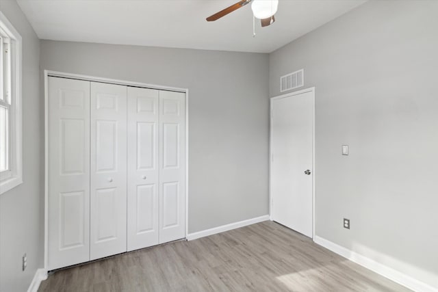 unfurnished bedroom with ceiling fan, a closet, and light wood-type flooring