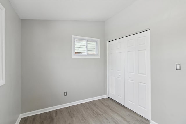 unfurnished bedroom with light wood-type flooring and a closet