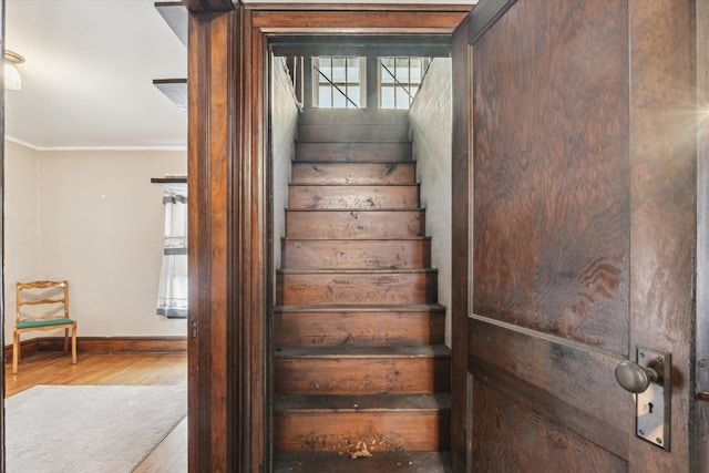 stairway featuring ornamental molding and hardwood / wood-style floors