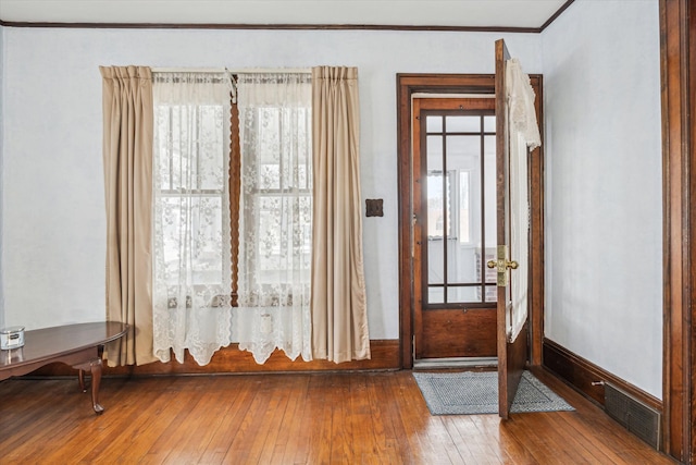 interior space with ornamental molding and hardwood / wood-style floors