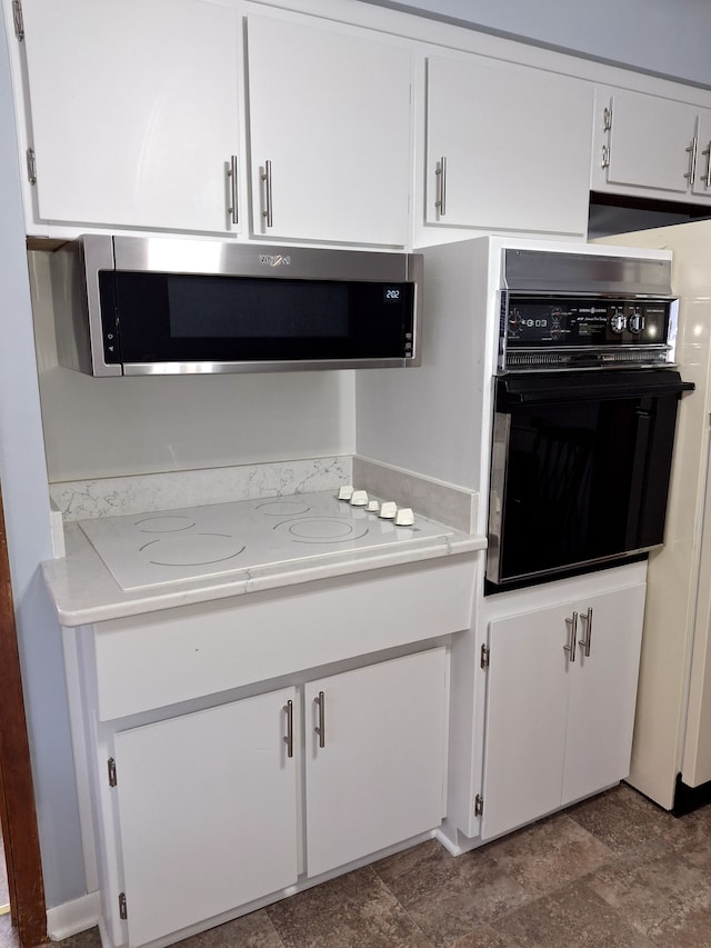 kitchen with white cabinetry, white electric cooktop, and oven