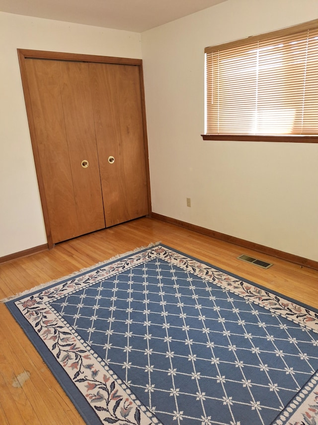 unfurnished bedroom with wood-type flooring and a closet