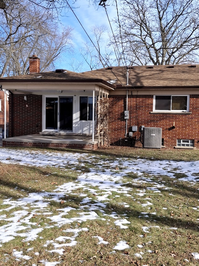 snow covered rear of property with central AC unit